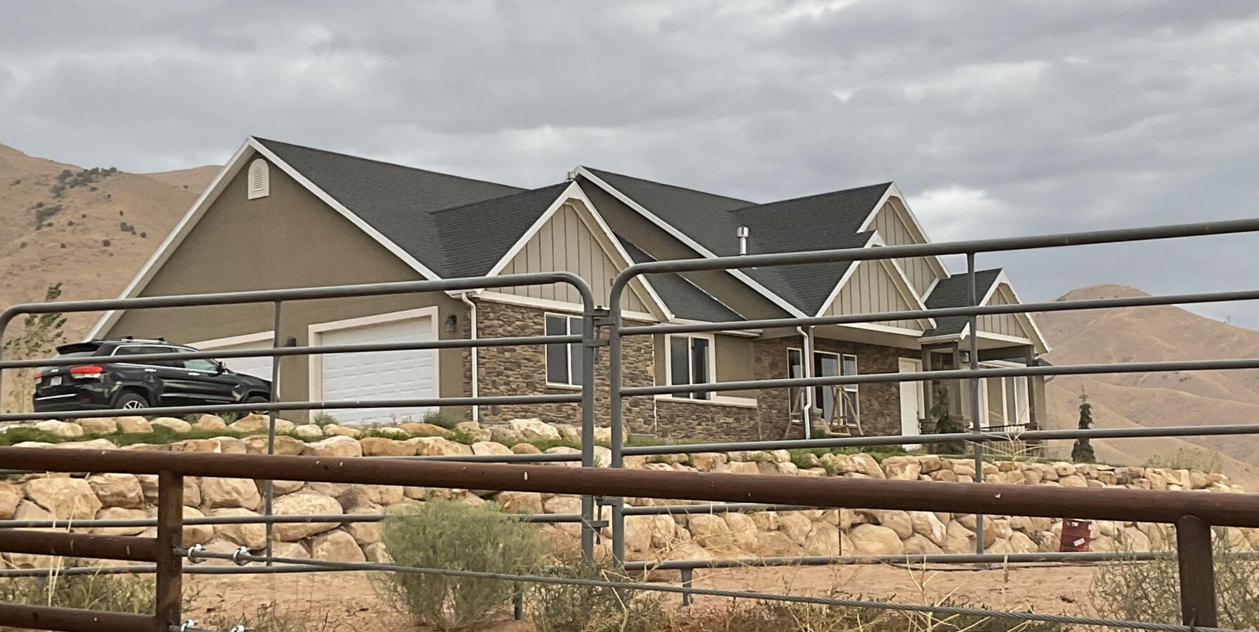 Brown and gray house on farm next to mountain Brown and gray house on farm next to mountain