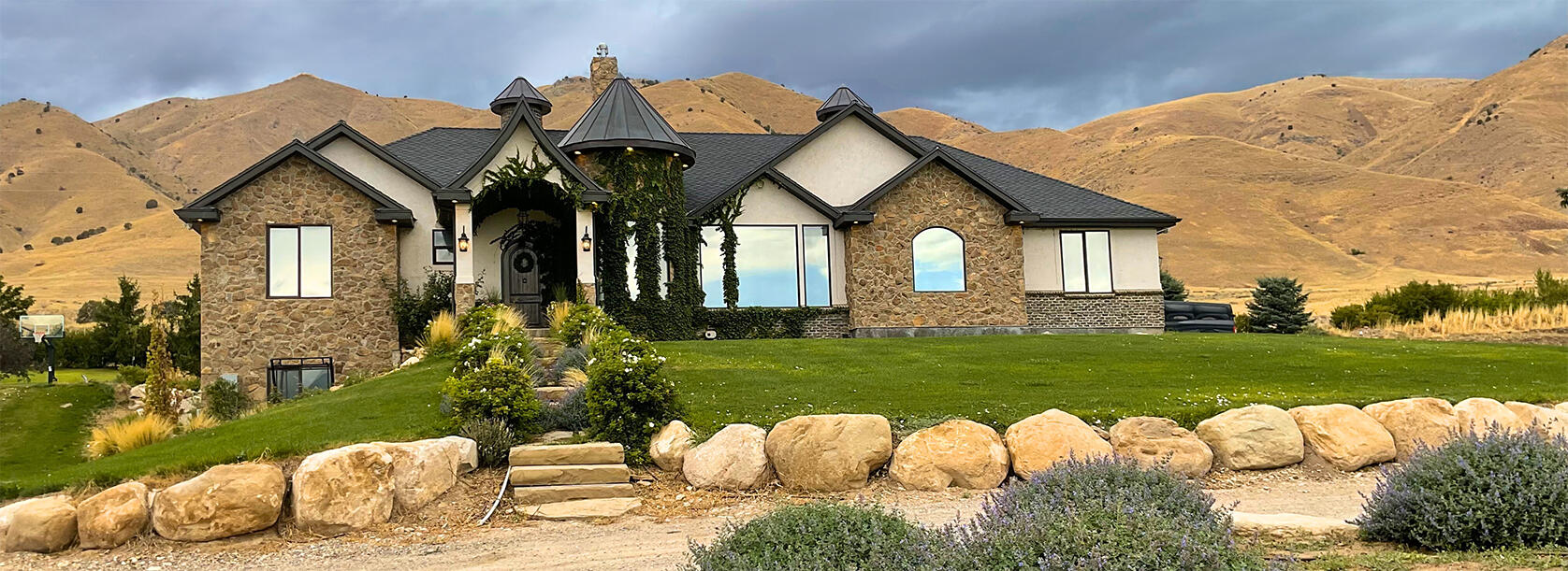 House with turret and lawn, with mountain in background